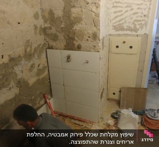 עובד מתקין אריחים על קיר במהלך שיפוץ
